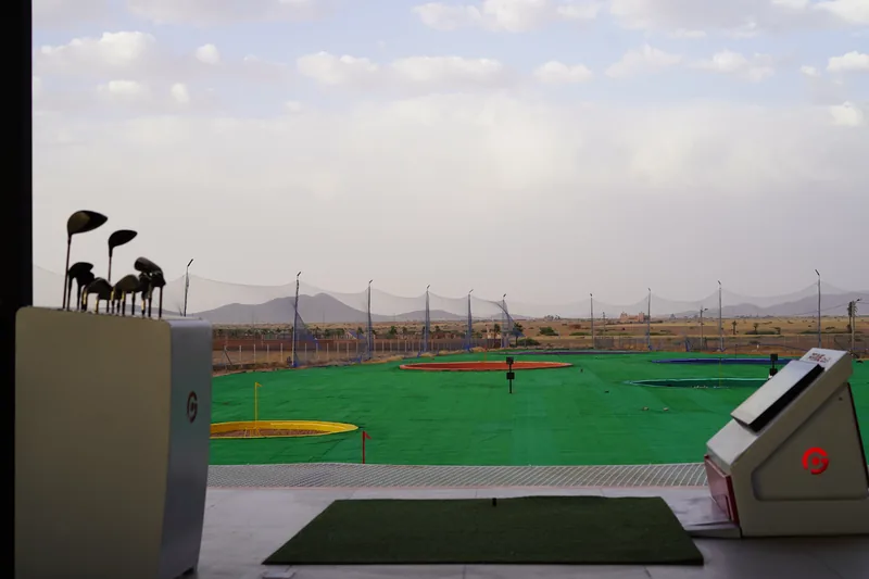 Vue sur le practice et les montagnes depuis une baie Prime Golf
