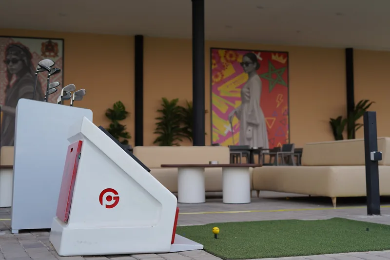 Kiosque connecté Prime Golf avec présentoir de clubs et fresque murale